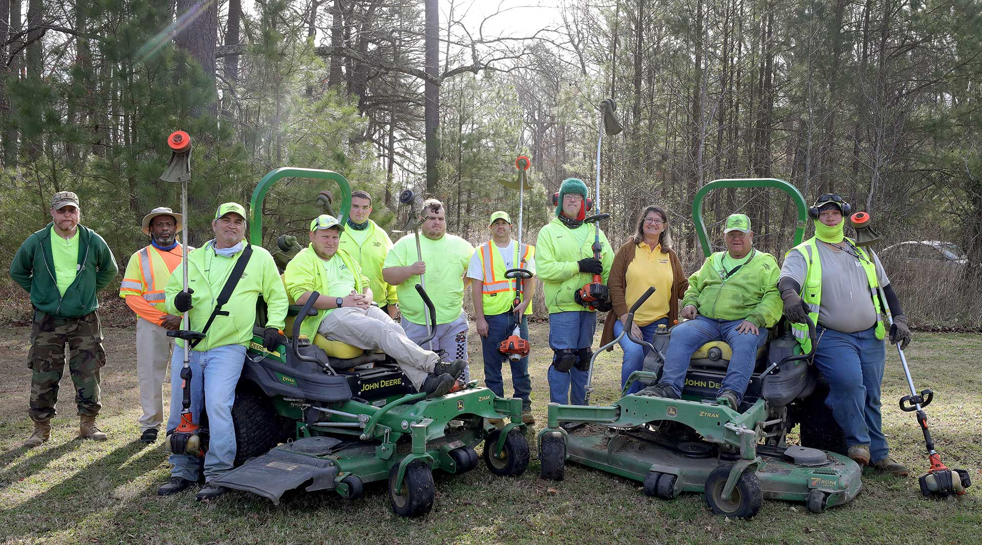 A lawn care crew poses with their equipment near Yorktown Naval Weapons Station