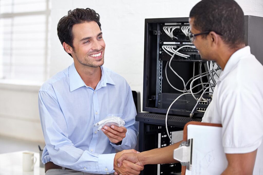 handshake with an engineer talking to a business man about cyber security.