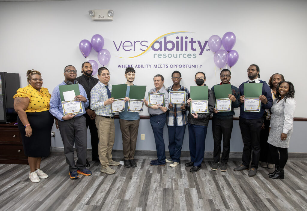 First graduating class from abilIT, students holding their certificates. 